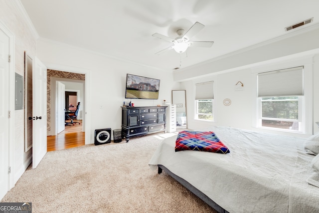 carpeted bedroom with electric panel, ceiling fan, and ornamental molding