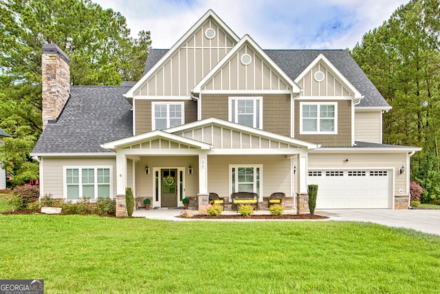 view of front of home featuring a front yard, a porch, and a garage