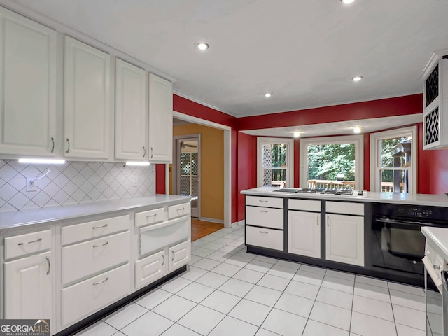 kitchen featuring oven, decorative backsplash, light tile patterned floors, white cabinetry, and stainless steel gas cooktop