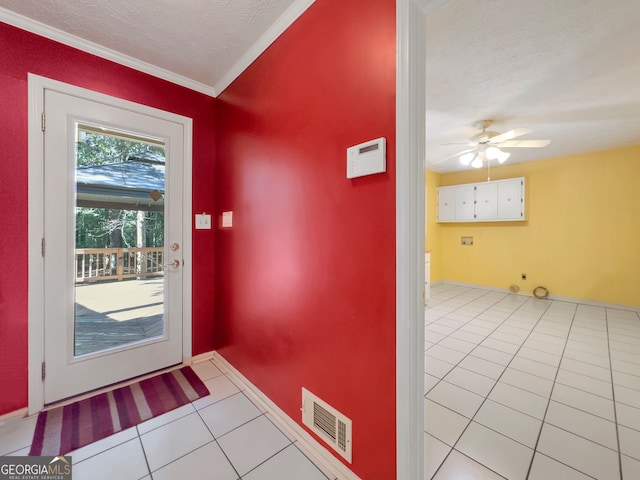 doorway featuring light tile patterned floors, a textured ceiling, ceiling fan, and crown molding