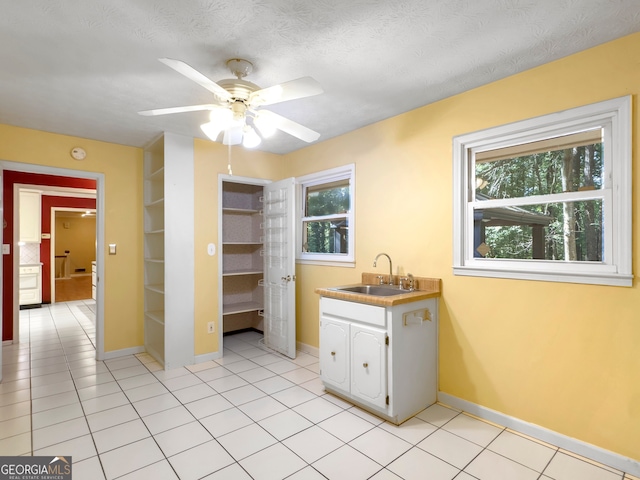 kitchen featuring ceiling fan, light tile patterned floors, sink, and a wealth of natural light