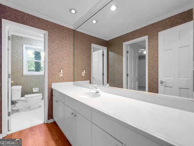 bathroom featuring vanity, crown molding, hardwood / wood-style flooring, ceiling fan, and toilet