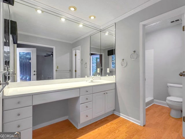 bathroom featuring hardwood / wood-style flooring, ceiling fan, ornamental molding, and vanity