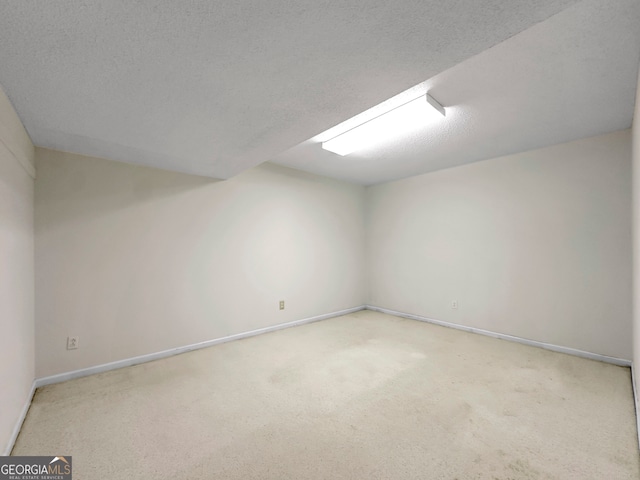 unfurnished room featuring light colored carpet and a textured ceiling