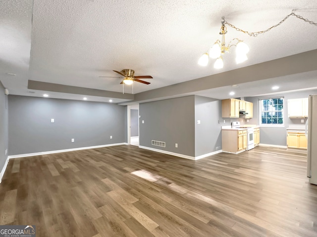 unfurnished living room with a textured ceiling, hardwood / wood-style floors, and ceiling fan with notable chandelier