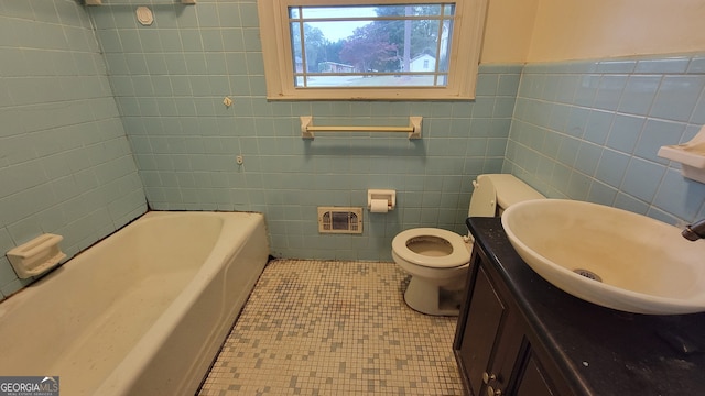 bathroom featuring tile patterned flooring, a tub to relax in, toilet, vanity, and tile walls