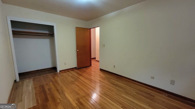 unfurnished bedroom with a closet and light hardwood / wood-style floors