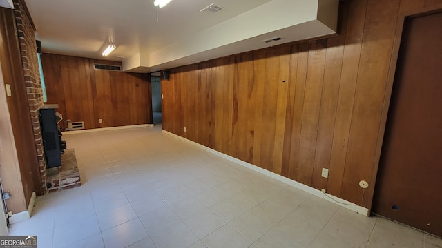 basement featuring a wood stove and wood walls