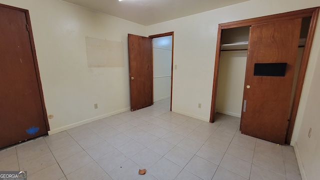 unfurnished bedroom with a closet and light tile patterned flooring