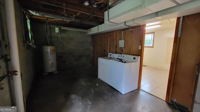 basement featuring washing machine and clothes dryer and electric water heater