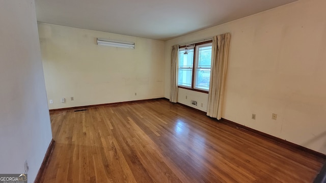 empty room with hardwood / wood-style flooring