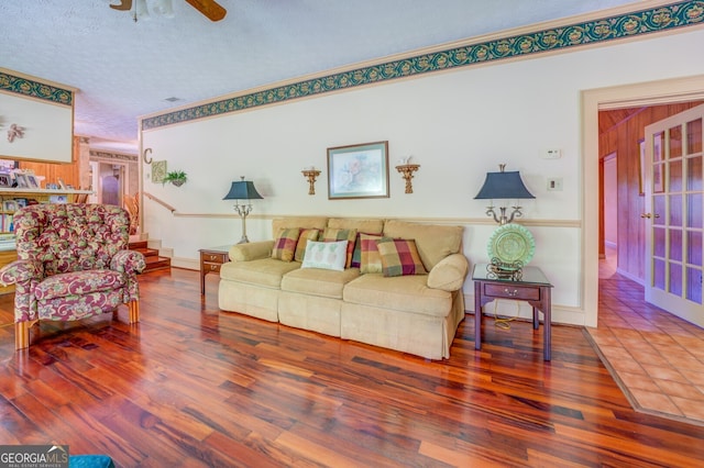 living room featuring hardwood / wood-style floors, a textured ceiling, and ceiling fan