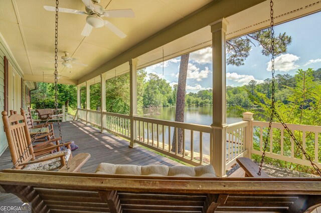 sunroom with a water view and ceiling fan