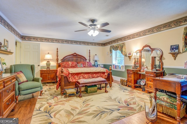 bedroom featuring a textured ceiling, light hardwood / wood-style flooring, ceiling fan, and crown molding