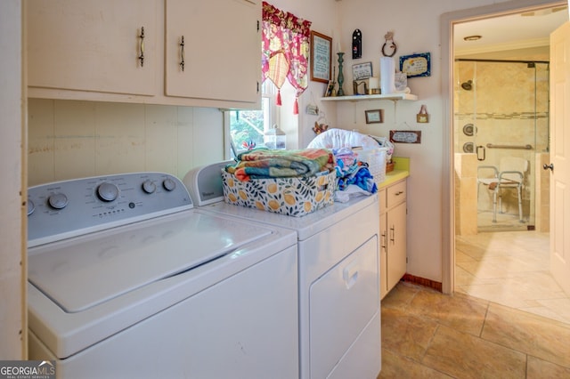 clothes washing area featuring washing machine and dryer and cabinets