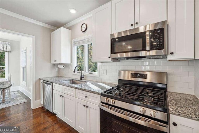 kitchen featuring light stone countertops, sink, dark hardwood / wood-style flooring, white cabinets, and appliances with stainless steel finishes