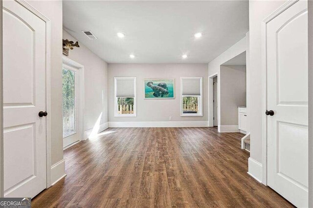 unfurnished living room with dark wood-type flooring