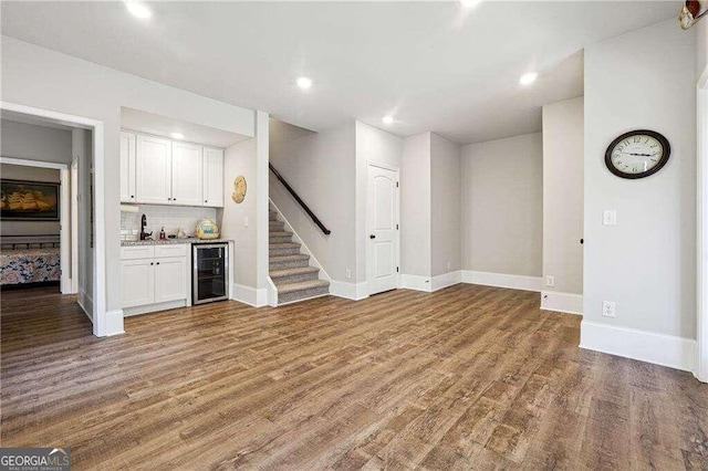 bar with white cabinets, hardwood / wood-style floors, wine cooler, and tasteful backsplash