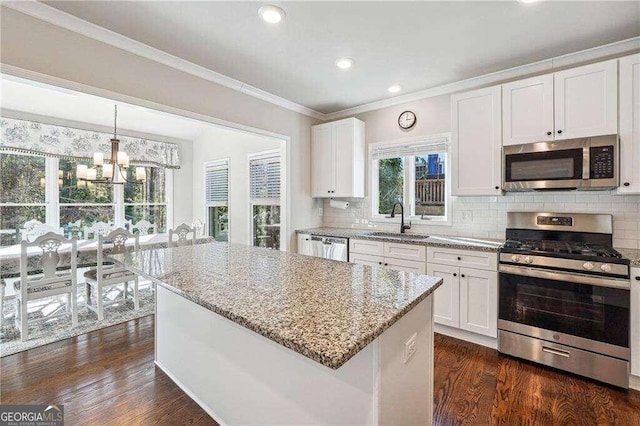 kitchen featuring white cabinetry, sink, a center island, dark hardwood / wood-style floors, and appliances with stainless steel finishes