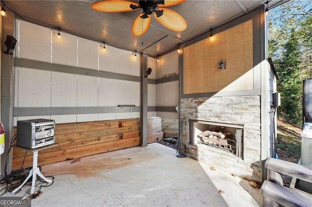 view of patio / terrace featuring an outdoor stone fireplace and ceiling fan