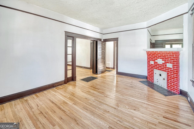 unfurnished living room with a textured ceiling and light wood-type flooring