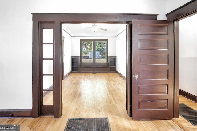 entryway with ceiling fan, ornamental molding, and light hardwood / wood-style flooring