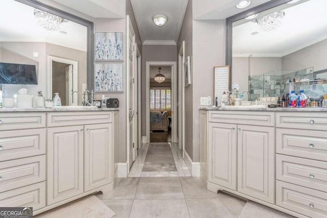 bathroom featuring tile patterned flooring, vanity, crown molding, and a notable chandelier