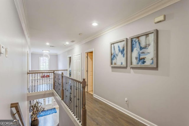 corridor with dark hardwood / wood-style floors, an inviting chandelier, and ornamental molding