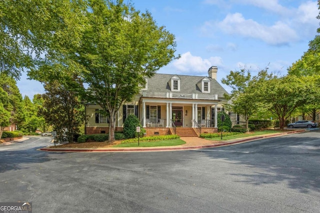 new england style home with a porch