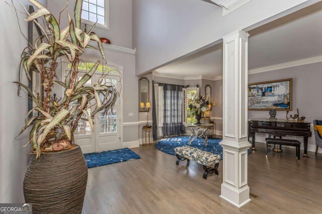 foyer entrance featuring ornate columns, hardwood / wood-style floors, and a healthy amount of sunlight