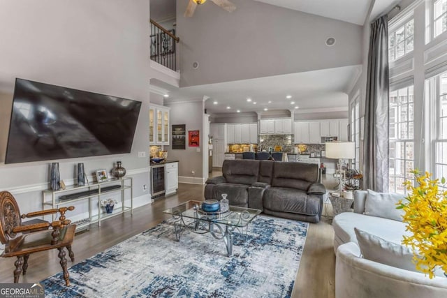 living room with wine cooler, ceiling fan, dark hardwood / wood-style flooring, and high vaulted ceiling