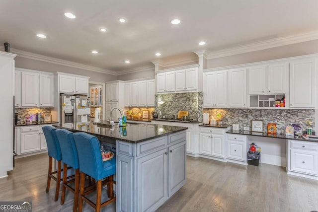 kitchen featuring white cabinets and a center island with sink