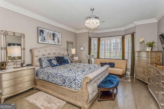 bedroom with an inviting chandelier, crown molding, and light hardwood / wood-style flooring