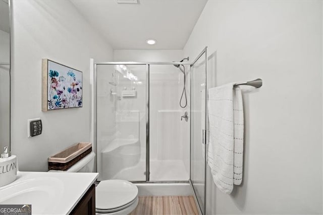 bathroom featuring vanity, toilet, and walk in shower