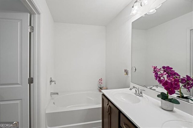 bathroom featuring vanity and a bath