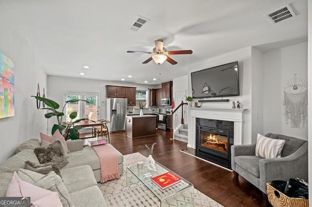 living room featuring ceiling fan and dark wood-type flooring