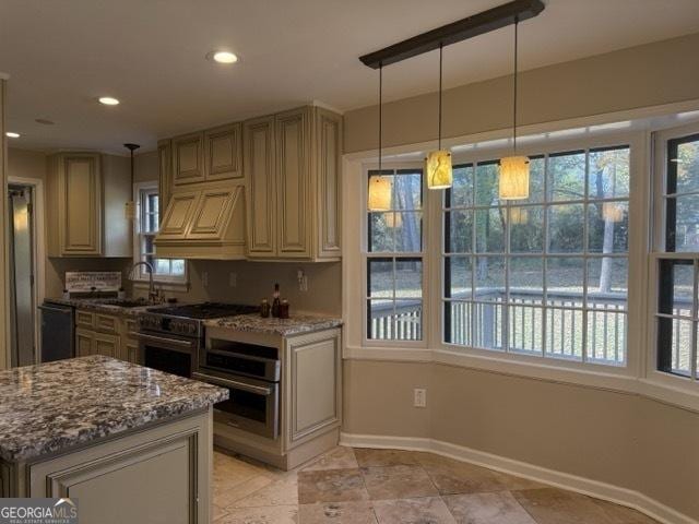 kitchen featuring dark stone counters, custom exhaust hood, stainless steel oven, sink, and pendant lighting