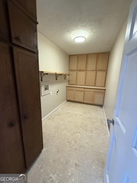 laundry area featuring cabinets, washer hookup, and a textured ceiling