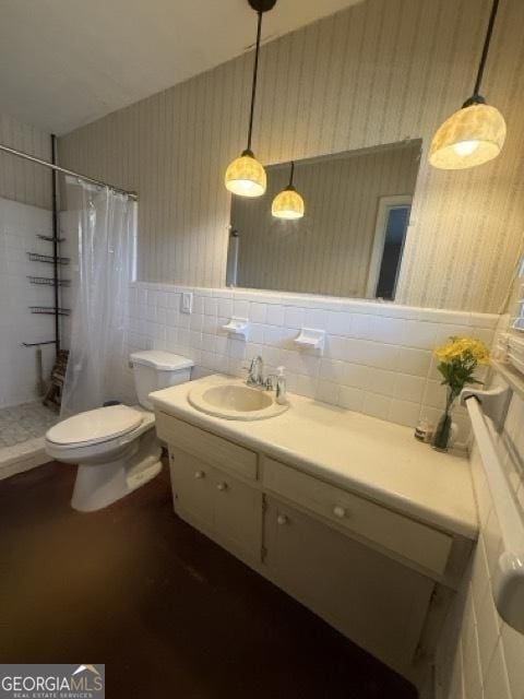 bathroom featuring a shower with curtain, vanity, toilet, and tile walls