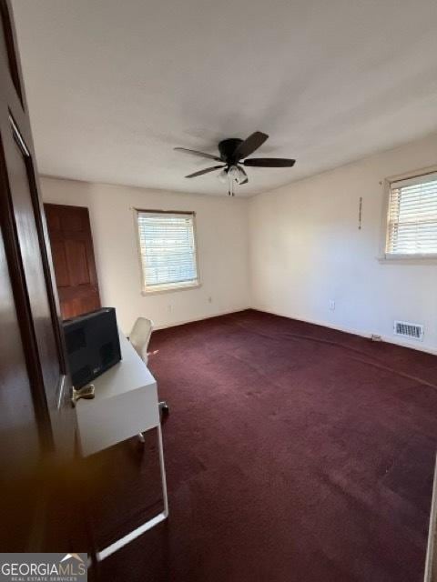 carpeted empty room with ceiling fan and a healthy amount of sunlight