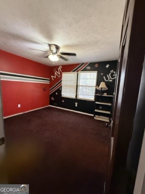 interior space featuring ceiling fan, carpet floors, and a textured ceiling