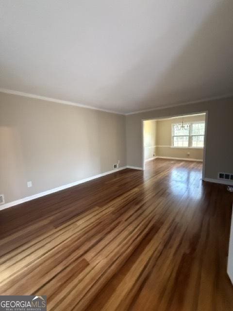 spare room with dark wood-type flooring and ornamental molding