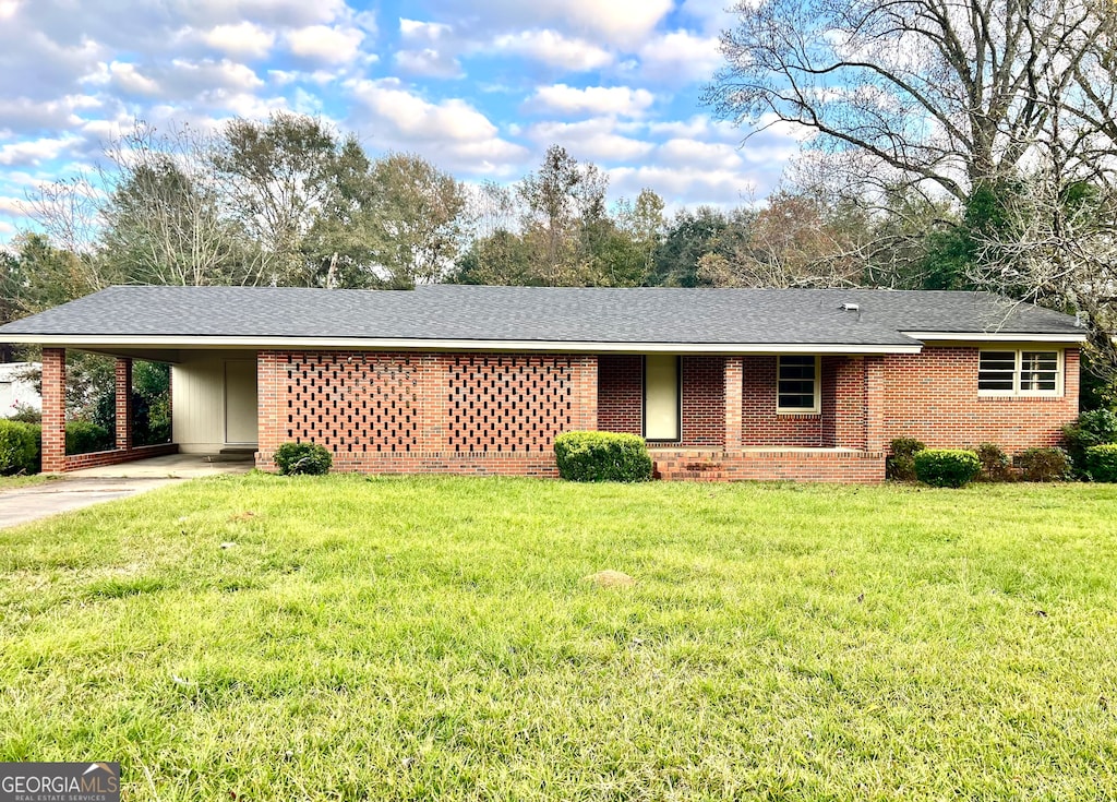 ranch-style house with a front yard and a carport