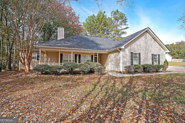 ranch-style house with covered porch and a front lawn