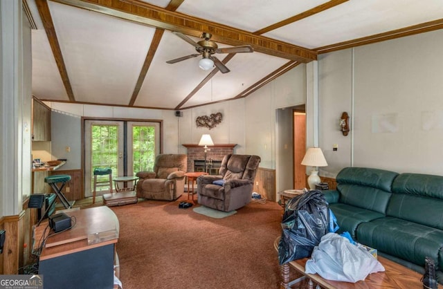 living room with carpet flooring, ceiling fan, wooden walls, lofted ceiling with beams, and a fireplace