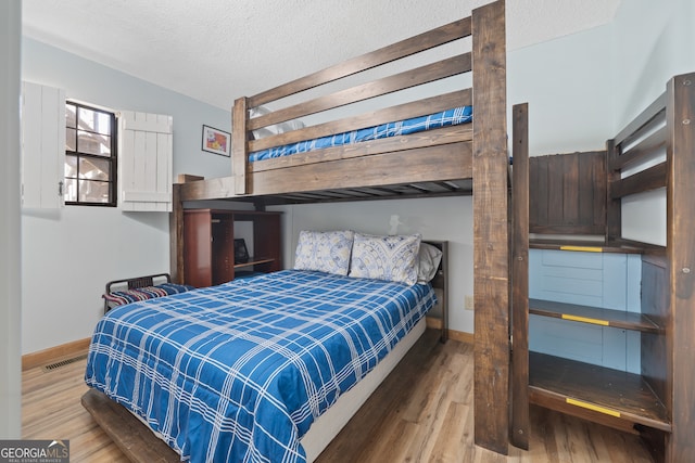 bedroom featuring hardwood / wood-style floors and a textured ceiling