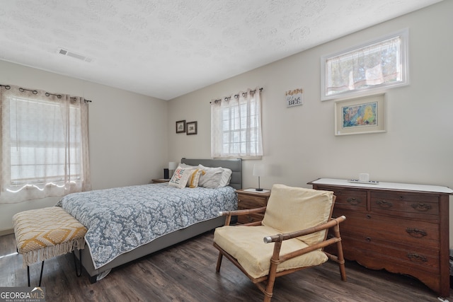 bedroom featuring a textured ceiling and dark hardwood / wood-style flooring