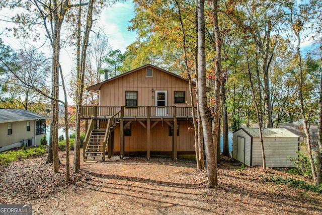 rear view of house with a shed and a deck