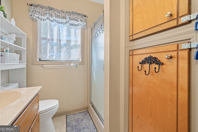 bathroom with tile patterned flooring, vanity, toilet, and an enclosed shower