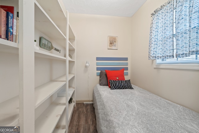 bedroom with a textured ceiling and dark wood-type flooring